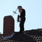 Chimney sweep inserting a brush